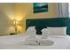 Close-up of a bedroom with a decorative headboard, pillows and folded towels on the bed at 1101 N Betty Ln, Clearwater, FL 33755