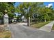 The property's entrance features stone pillars with lion statues and a black iron fence amidst mature trees at 1101 N Betty Ln, Clearwater, FL 33755