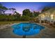 Inviting backyard with a large pool, seating area, and lush landscaping at twilight at 1101 N Betty Ln, Clearwater, FL 33755