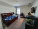 A bedroom with carpet, featuring a bed, desk, TV and fish tanks at 11134 Horned Owl Rd, Weeki Wachee, FL 34614