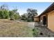 Backyard view shows a flat yard, with some ground cover and a portion of the side exterior at 1358 Newhope Rd, Spring Hill, FL 34606