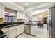 Bright kitchen featuring granite countertops, stainless steel appliances and white cabinets at 1358 Newhope Rd, Spring Hill, FL 34606