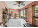 Bright sunroom featuring tiled floors, a ceiling fan, access to the backyard, and ample space for various activities at 1358 Newhope Rd, Spring Hill, FL 34606