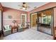 Bright sunroom featuring tiled flooring, wicker chairs with pillows, and a view of the garden and a glimpse into the dining area at 1358 Newhope Rd, Spring Hill, FL 34606