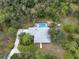 Aerial view of the home with a metal roof, a pool, and lush landscaping at 16411 County Road 675, Parrish, FL 34219