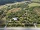 Aerial view of a large treed parcel featuring a home with a pool, providing a sense of privacy at 16411 County Road 675, Parrish, FL 34219