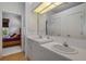 Bathroom featuring double sinks, a large mirror, and a view into the bedroom at 16411 County Road 675, Parrish, FL 34219