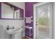 Bathroom featuring a sleek pedestal sink, a large mirror, and an exterior door at 16411 County Road 675, Parrish, FL 34219