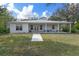 Charming single-story home with a metal roof, a covered porch, and manicured front lawn at 16411 County Road 675, Parrish, FL 34219