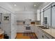 Well-lit kitchen with white cabinets, modern appliances, and warm wooden floors at 16411 County Road 675, Parrish, FL 34219