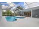 Enclosed pool and patio area with hot tub, lounge chairs, and outdoor dining set at 16411 County Road 675, Parrish, FL 34219
