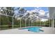 Swimming pool in screened enclosure surrounded by mature trees and landscaping at 16411 County Road 675, Parrish, FL 34219