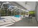 Screened-in pool area with a pool, hot tub, and outdoor dining space at 16411 County Road 675, Parrish, FL 34219