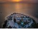 Breathtaking aerial shot of a coastal area with a beach, parking, green spaces, and waterfront at 1723 Gulf Rd # 104, Tarpon Springs, FL 34689