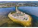Aerial view of a beautiful beach with palm trees, parking, and calm waters at 1723 Gulf Rd # 104, Tarpon Springs, FL 34689