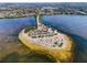 Aerial view of a beautiful beach with palm trees, parking, and calm waters at 1723 Gulf Rd # 104, Tarpon Springs, FL 34689