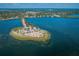 Breathtaking aerial perspective of an island paradise with beach, lush trees, shelter, and surrounding bay at 1723 Gulf Rd # 104, Tarpon Springs, FL 34689
