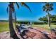 Outdoor dining set on a patio with tropical trees, perfect for enjoying waterfront views and relaxation at 1723 Gulf Rd # 104, Tarpon Springs, FL 34689