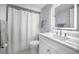 Modern bathroom featuring an illuminated mirror, white vanity, and shower-tub combination at 1723 Gulf Rd # 104, Tarpon Springs, FL 34689