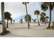 Picturesque beach featuring white sand and lush palm trees under a cloudy sky at 1723 Gulf Rd # 104, Tarpon Springs, FL 34689