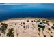 Aerial view of a tranquil beach featuring palm trees, a green shelter, and calm blue waters at 1723 Gulf Rd # 104, Tarpon Springs, FL 34689
