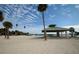 Close up look at stage and shelter on sandy beach with view of other shelter and palm trees at 1723 Gulf Rd # 104, Tarpon Springs, FL 34689