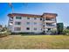 Multi-story condo building featuring balconies and well-maintained landscaping for curb appeal at 1723 Gulf Rd # 104, Tarpon Springs, FL 34689