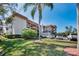 Landscaped exterior of a condominium building with parking and mature trees at 1723 Gulf Rd # 104, Tarpon Springs, FL 34689