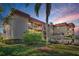 Well-maintained exterior of a multi-story building featuring balconies and neat landscaping at 1723 Gulf Rd # 104, Tarpon Springs, FL 34689