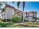 Well-maintained exterior of a multi-story building featuring balconies and neat landscaping at 1723 Gulf Rd # 104, Tarpon Springs, FL 34689