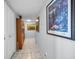 Hallway featuring tiled floors, art and a bookcase full of books at 1723 Gulf Rd # 104, Tarpon Springs, FL 34689