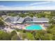 Aerial view of the clubhouse and pool, showing a bright community gathering spot with a relaxing pool and ample seating at 18030 Webster Grove Dr, Hudson, FL 34667