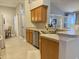 Bright kitchen features wood cabinets, stainless steel dishwasher and tile floors at 18030 Webster Grove Dr, Hudson, FL 34667