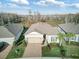 An aerial view of a single-Gathering home with a well-maintained lawn, landscaping and a two car garage at 18629 Coastal Shore Ter, Land O Lakes, FL 34638
