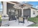 A covered patio and backyard with a grill and dining area, perfect for outdoor gatherings at 18629 Coastal Shore Ter, Land O Lakes, FL 34638