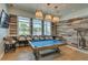 Bright game room features a pool table with view to the outside pool and chairs for spectators at 18629 Coastal Shore Ter, Land O Lakes, FL 34638
