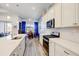 Open kitchen with stainless appliances, light countertops, and an adjacent dining area with backyard views at 18629 Coastal Shore Ter, Land O Lakes, FL 34638