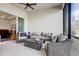 Relaxing screened lanai with comfortable seating, ceiling fan, and sliding doors leading to the home's interior at 18629 Coastal Shore Ter, Land O Lakes, FL 34638