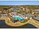 An aerial view showcases the community pool, tennis courts, and surrounding lakes and landscape at 19504 Lily Pond Ct, Brooksville, FL 34601