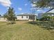Expansive grassy backyard featuring an exterior view of the home's screened-in porch, great for outdoor enjoyment at 19504 Lily Pond Ct, Brooksville, FL 34601