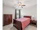 Cozy bedroom with a ceiling fan, wooden furniture, and natural light from the window at 19504 Lily Pond Ct, Brooksville, FL 34601