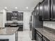Kitchen with granite countertops, stainless steel appliances, tile flooring, and dark wood cabinetry at 19504 Lily Pond Ct, Brooksville, FL 34601