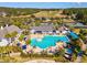 Aerial view of a resort-style pool with palm trees, lounge chairs, and a clubhouse, perfect for relaxing and socializing at 19504 Lily Pond Ct, Brooksville, FL 34601