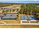 Aerial view of tennis courts with well-maintained playing surfaces, located near a picturesque lake and golf course at 19504 Lily Pond Ct, Brooksville, FL 34601
