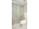 Bathroom featuring a toilet next to a shower with a sliding glass door at 2101 Sunset Point Rd # 2706, Clearwater, FL 33765