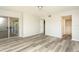 Bedroom features wood-style flooring and closet doors leading to outdoor space and view into bathroom at 2101 Sunset Point Rd # 2706, Clearwater, FL 33765