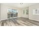 Bright bedroom with wood-look flooring, natural light from a large glass sliding door, and balcony access at 2101 Sunset Point Rd # 2706, Clearwater, FL 33765