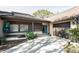 Single-story home featuring light brick, brown siding, concrete driveway, and well-maintained landscaping at 2101 Sunset Point Rd # 2706, Clearwater, FL 33765