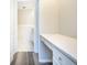 Hallway showing entrance to the bathroom with a white marble floor, and a built-in desk at 2101 Sunset Point Rd # 2706, Clearwater, FL 33765