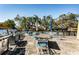 An outdoor grill on a brick patio surrounded by tables and umbrellas at 2101 Sunset Point Rd # 2706, Clearwater, FL 33765